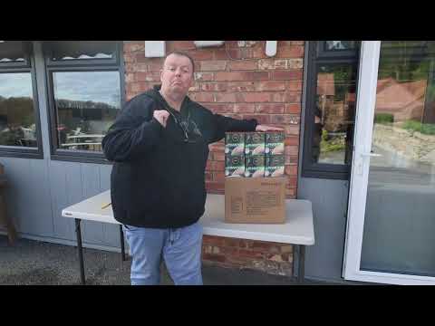 a man standing in front of a building holding a box of fireworks