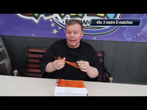 a man sitting at a table holding a pack of e-matches