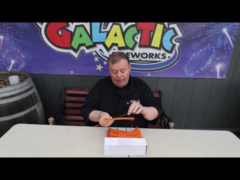 a man sitting at a table holding a pack of e-matches