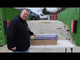 a man standing next to a table with boxes of fireworks on it