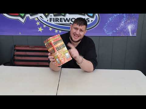 Man presenting Proton Bomb Xtreme 16-shot firework cake by Bright Star, highlighting its size and packaging at a fireworks retailer.