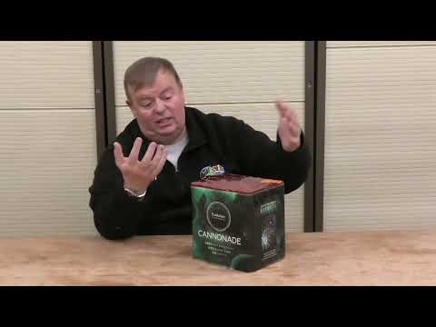 Man presenting Cannonade 30-shot firework cake by Evolution Fireworks, ideal for showcasing product size and packaging in party supply reviews.