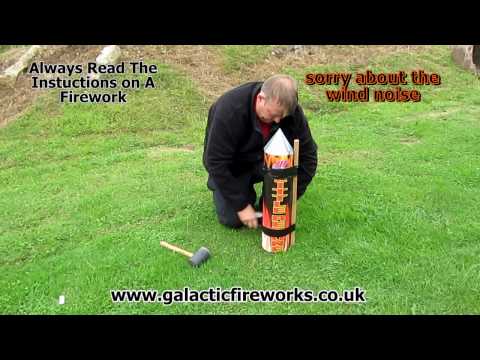 Man using 50m Long Gaffa Tape for Fireworks to secure a large rocket to a wooden stake, demonstrating safe fireworks setup.