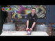 Presenter showcasing Sky Breaker firework cake by Primed Pyrotechnics at Galactic Fireworks store, highlighting its party display features.