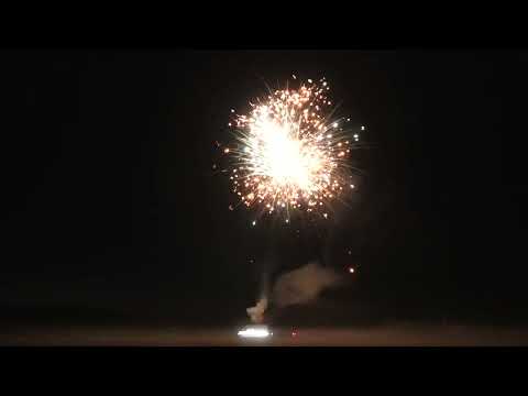 Firework burst from Volt's 1.2" Mixed Gold to Blue Compound Cake showing golden and blue effects during a nighttime display.