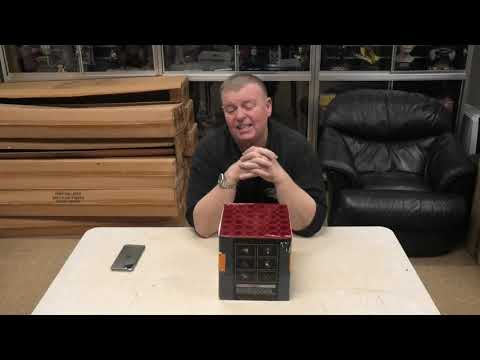 Presenter showcasing Electron 36-shot cake firework by Evolution Fireworks on a table, highlighting its compact design and performance.