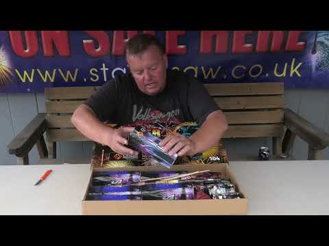 a man sitting at a table in front of a box of fireworks