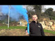 Man holding an active Blue Handheld Smoke Grenade by Cube Fireworks emitting dense blue smoke, ideal for gender reveals and outdoor events.