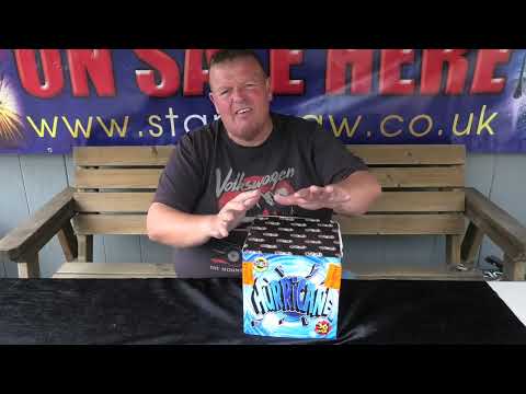 Presenter showcasing Hurricane 36-shot firework cake by Evolution, highlighting its features for party and celebration use.