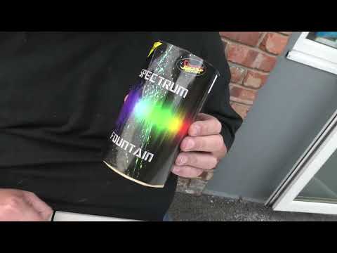 Person holding Spectrum Fountain firework by Standard Fireworks, showcasing its compact size and colorful label for party use.