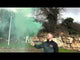 Man holding active Green Handheld Smoke Grenade by Cube Fireworks emitting dense green smoke, ideal for photoshoots and special events.