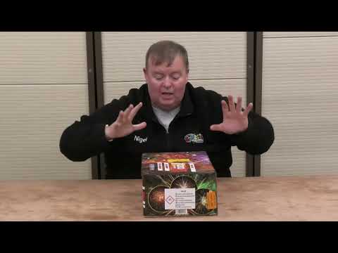 Presenter showcasing Legion 100-shot cake by Black Panther Fireworks, highlighting features and packaging design on a review table.